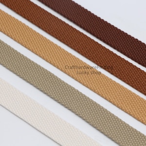 Pu&ograve; includere: Cinque colori diversi di fettuccia di cotone, dal bianco al marrone. La fettuccia &egrave; piatta e ha una trama tessuta. Il testo "CrafthardwareFinding Lucky shop" &egrave; visibile al centro dell'immagine.