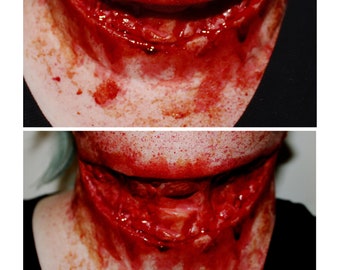 May include: A close-up of a fake, bloody wound on a person's neck. The wound is open and raw, with blood dripping down the neck. The wound is a realistic special effects makeup application.