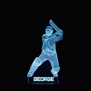 May include: A blue 3D printed night light shaped like a cricket player holding a bat. The name "GEORGE" is printed on the base of the light.