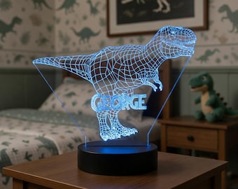 May include: A blue LED dinosaur night light with the name "GEORGE" illuminated on its side. The dinosaur is a wireframe design, sitting on a black base. The light is on a wooden table in a room with dinosaur-themed decor.