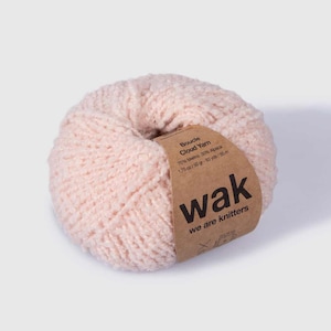 Pode incluir: Um novelo de fio bouclé rosa com a etiqueta "Boucle Cloud Yarn" com o texto "70% Merino 30% Alpaca 1,75 oz/50g - 93 yds/85 m" e "wak we are knitters".