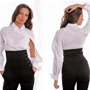 May include: A white long-sleeved shirt with a black high-waisted belt. The belt has multiple buttons down the side.