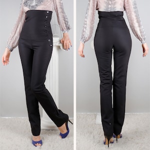 Puede incluir: Pantalones negros de cintura alta con botones en el lateral. Los pantalones tienen un corte ajustado y se combinan con tacones azules. Los pantalones se muestran de frente y de espalda.