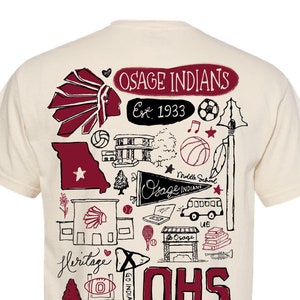 May include: A beige t-shirt with a maroon and black graphic design. The design features a variety of images, including a Native American headdress, a school building, a basketball, a football, a baseball, a tennis racket, a trumpet, a book, a school bus, and the text "Osage Indians Est. 1933" and "OHS".