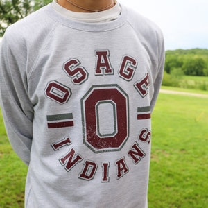 May include: A gray sweatshirt with a maroon and gray graphic of "Osage Indians" with a large "O" in the center.