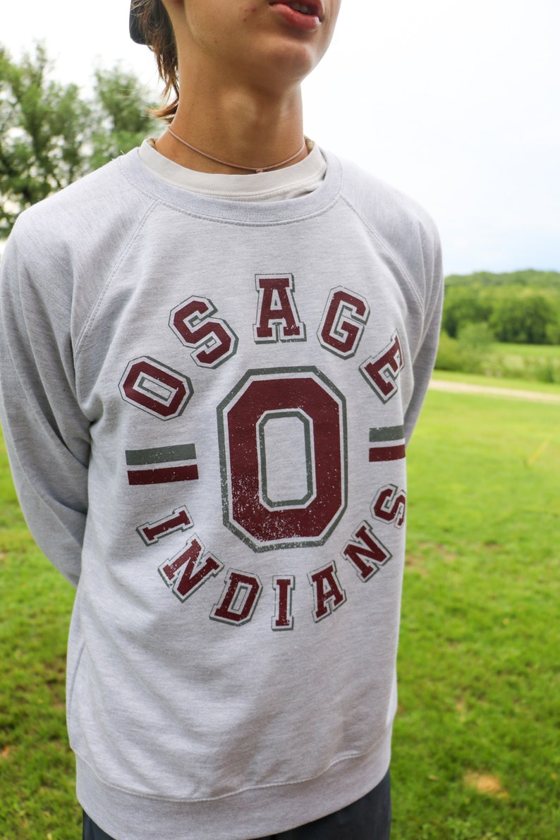 May include: A gray sweatshirt with a maroon and gray graphic of "Osage Indians" with a large "O" in the center.