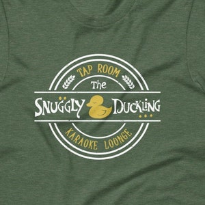May include: Green t-shirt with a white circle logo that says "The Snuggly Duckling Tap Room Karaoke Lounge" with a yellow rubber duck inside the circle.