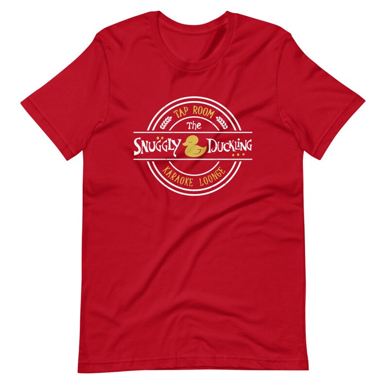 May include: Red t-shirt with a white circle logo that says "The Snuggly Duckling Tap Room Karaoke Lounge" with a yellow rubber duck inside the circle.