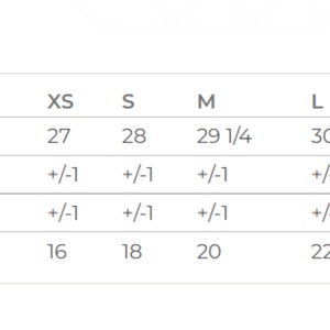 May include: Size chart for a garment with measurements in inches for body length, chest width, and tolerance for each size from XS to 3XL.