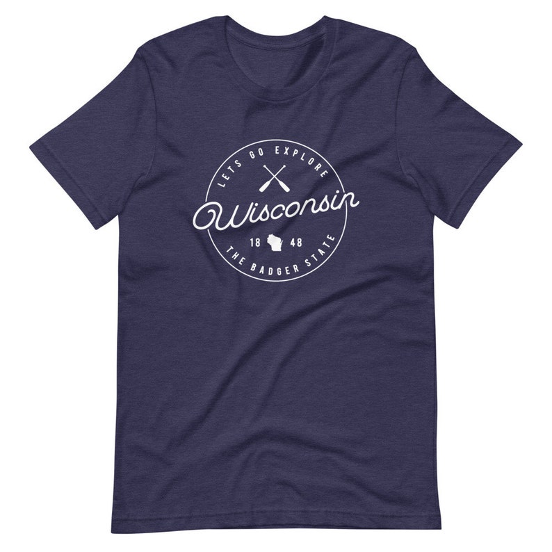 May include: Navy blue t-shirt with a white circle graphic that says "Let's Go Explore Wisconsin" with crossed paddles, a Wisconsin state outline, and "The Badger State" with the numbers 18 and 48.