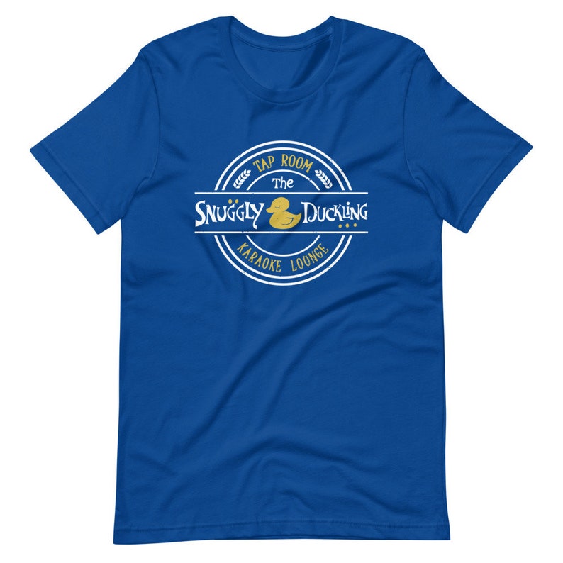May include: Blue t-shirt with a white circle logo that says "The Snuggly Duckling Tap Room Karaoke Lounge" with a yellow rubber duck inside the circle.