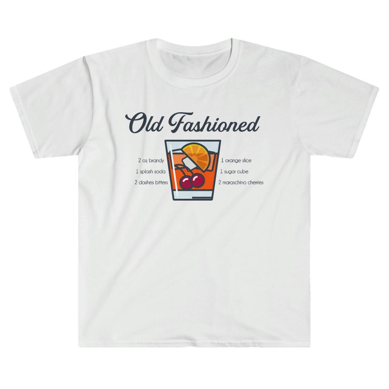 May include: White t-shirt with a graphic of an Old Fashioned cocktail recipe. The graphic includes a glass of the cocktail with a cherry, orange slice, and sugar cube. The text reads "Old Fashioned" and lists the ingredients: 2 oz brandy, 1 splash soda, 2 dashes bitters, 1 orange slice, 1 sugar cube, and 2 maraschino cherries.