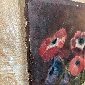 K&ouml;nnte beinhalten: Ein Vintage-&Ouml;lgem&auml;lde auf Leinwand, das ein Stillleben mit roten, violetten und wei&szlig;en Blumen in einer wei&szlig;en Vase darstellt. Der Hintergrund ist dunkelbraun.