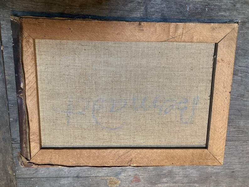 K&ouml;nnte beinhalten: Nahaufnahme der R&uuml;ckseite eines gerahmten Gem&auml;ldes. Die Leinwand ist hellbeige und tr&auml;gt eine schwach blaue Inschrift mit dem Text "C.E. 1971".