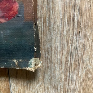 K&ouml;nnte beinhalten: Nahaufnahme des Randes eines Gem&auml;ldes auf Leinwand. Die Leinwand ist auf einen Holzrahmen gespannt und der Rand ist mit Heftklammern befestigt. Das Gem&auml;lde ist eine Stillleben mit roten Blumen.