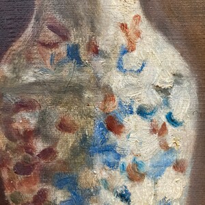 K&ouml;nnte beinhalten: Nahaufnahme einer wei&szlig;en Porzellanvase mit blauen und braunen Blumendesigns. Die Vase ist in einem lockeren, impressionistischen Stil bemalt.