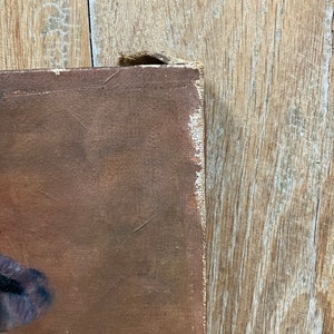 K&ouml;nnte beinhalten: Eine Nahaufnahme des Randes eines braunen Leinwandgem&auml;ldes mit einem Holzrahmen. Die Leinwand ist &uuml;ber den Rahmen gespannt und die Kanten sind sichtbar. Das Gem&auml;lde befindet sich auf einer Holzoberfl&auml;che.