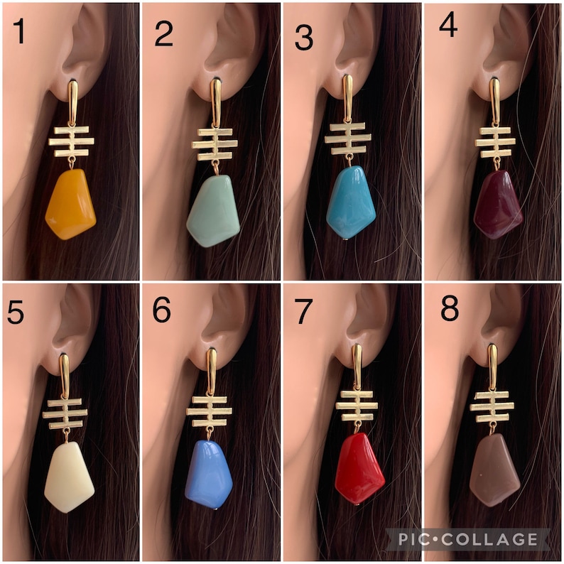 May include: Eight pairs of gold geometric earrings with different colored stone accents. The stones are in shades of yellow, green, blue, red, white, brown, and gray.