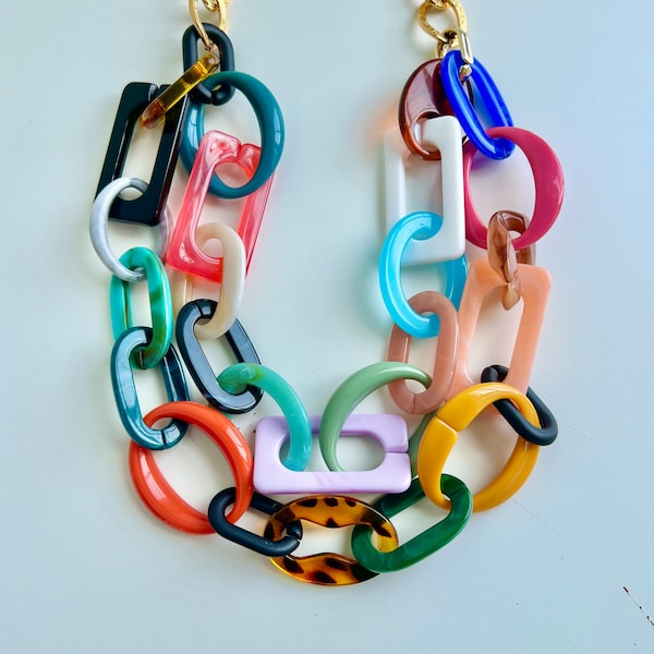 May include: A colorful plastic necklace with links in various shapes and colors, including turquoise, green, red, orange, purple, and white.