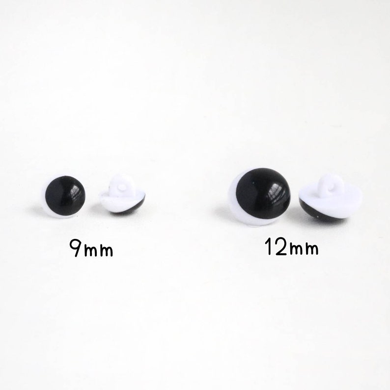 Op de afbeelding: Twee sets ronde, zwart-witte plastic knopen die op ogen lijken, gelabeld als 9mm en 12mm. Elke knoop heeft een glad, zwart bolvormig midden omringd door een witte rand en is voorzien van een klein oogje aan de achterkant voor bevestiging.