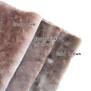 May include: Three fabric swatches in different shades of pink and brown. The top swatch is a light dusty pink, the middle swatch is a darker dusty pink, and the bottom swatch is a light brown.