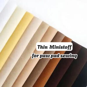 Puede incluir: Una colección de tiras de tela delgadas dispuestas en un degradado de blanco a negro, incluyendo tonos amarillos, beige, bronceados y marrones. El texto "Thin Ministoff for paw pad sewing" está superpuesto en el centro de las tiras.