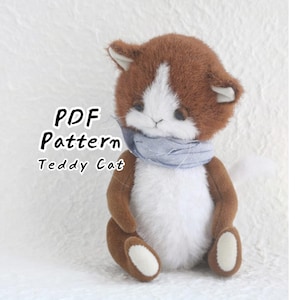 Puede incluir: Un juguete de peluche con forma de gato con pelaje marrón y blanco, que lleva una bufanda de tela azul claro alrededor del cuello. El texto "PDF Pattern Teddy Cat" está impreso en negro a la izquierda, indicando una guía de costura.