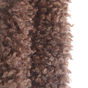 May include: Close-up of a brown, curly fur texture. The fur has a dense, wavy pattern with varying shades of brown, creating a soft and inviting appearance. The texture is detailed and appears to be a natural material.
