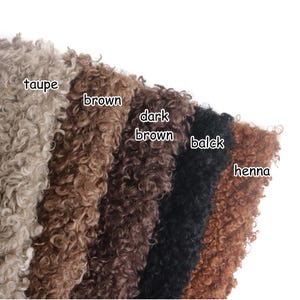 May include: Five swatches of curly, textured faux fur fabric arranged in a fan shape. The colors are labeled as taupe, brown, dark brown, balck, and henna. Each piece of fabric displays a dense, coiled pile with a consistent, uniform appearance.