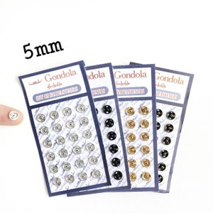 May include: Four cards of sew-on snap fasteners in silver, black, and gold. Each card has 24 snaps and the text "Gondola Sew-on Snap Fasteners".