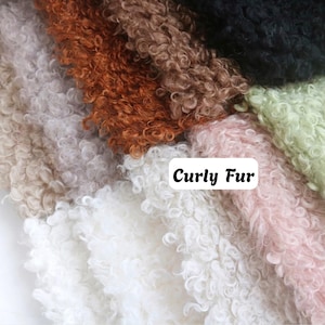 May include: A collection of curly faux fur fabric swatches in various colors including white, light pink, light green, black, brown, and beige. A white rectangular label with rounded corners is centered, featuring the black text Curly Fur.