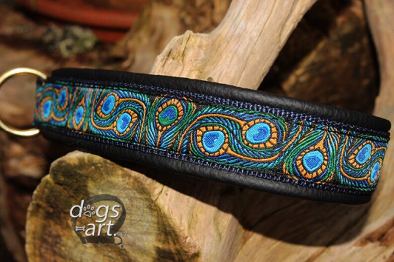 May include: A black leather dog collar with a peacock feather pattern in blue, green, and gold. The collar has a metal D-ring.