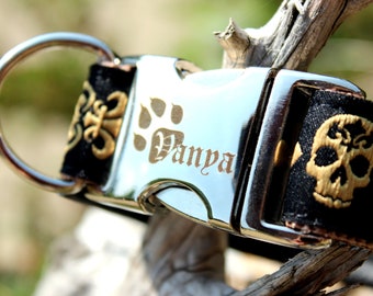 Puede incluir: Un collar de perro negro y dorado con una hebilla plateada. La hebilla está grabada con una huella de pata y el nombre "Vanya".