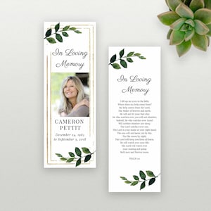 Puede incluir: Un marcapáginas con un marco dorado y hojas verdes. El marcapáginas presenta una foto de una mujer y el texto "In Loving Memory" y "Cameron Pettit, December 24, 1965 to September 3, 2018". La parte posterior del marcapáginas tiene un poema sobre el Señor que vela por ti.