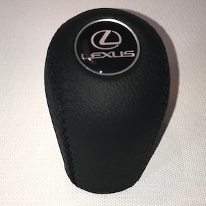 May include: Black leather gear shift knob with a silver Lexus logo.