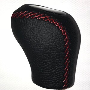 May include: Black leather gear shift knob with red stitching.