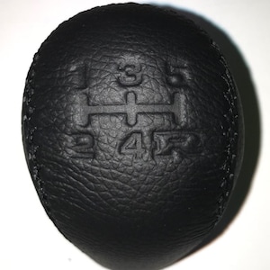 May include: Black leather gear shift knob with embossed numbers 1, 2, 3, 4, 5, and R.