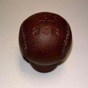 Può includere: Pomello del cambio in pelle marrone con un motivo cucito e marchi in rilievo per 2, 4 e R.