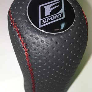 May include: Black leather gear shift knob with red stitching and a silver F SPORT logo.