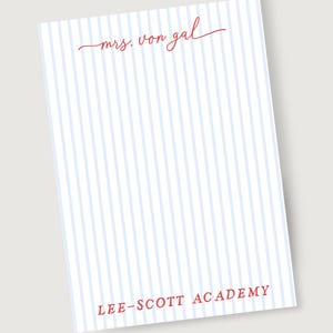 Puede incluir: Bloc de notas con un patrón de rayas azules claras y blancas. Las palabras "mrs. von gal" están escritas en rojo en la parte superior, y "LEE-SCOTT ACADEMY" está impreso en rojo en la parte inferior.