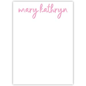 May include: A rectangular white notepad featuring the name mary kathryn printed in a pink cursive script font at the top center. The paper is blank below the name, providing a large space for writing notes or lists on the white surface.