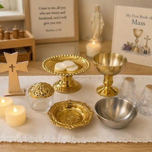 May include: A collection of religious items including a wooden cross, a gold-toned pedestal plate with white wafers, a gold chalice, a small glass jar with a gold lid, a gold decorative dish, a silver bowl, two glass cruets, and two LED candles.