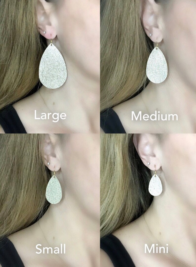 May include: Four pairs of teardrop-shaped leather earrings in different sizes: large, medium, small, and mini. The earrings are a light cream color with a subtle shimmer.