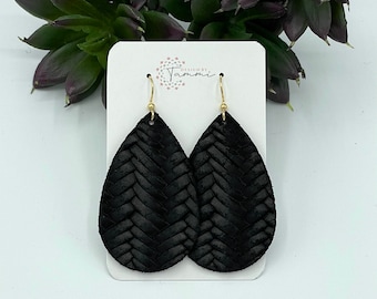 May include: Black leather earrings with a woven design. The earrings are teardrop shaped and have gold hooks.
