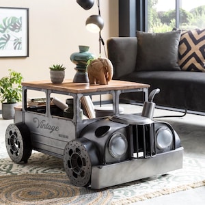 Könnte beinhalten: Ein Couchtisch im Vintage-Stil in Form eines klassischen Autos. Der Tisch hat eine Holzplatte und einen Metallrahmen mit dem Wort "Vintage" an der Seite. Die Räder sind groß und dekorativ, und die Scheinwerfer sind markant.
