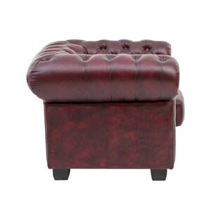 Puede incluir: Un sill&oacute;n de cuero burdeos con respaldo capiton&eacute; y brazos enrollados. El sill&oacute;n tiene un dise&ntilde;o cl&aacute;sico y est&aacute; tapizado en un cuero rico y desgastado.