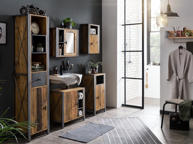 May include: A rustic bathroom set featuring wooden cabinets with metal frames. The set includes a tall cabinet, a vanity with a sink, and wall-mounted cabinets. A gray rug and a neutral-colored bathrobe complete the bathroom decor. A decorative motorcycle model sits atop the tall cabinet.