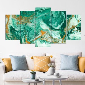May include: A five-piece canvas wall art set featuring an abstract green and gold marble design. The artwork is displayed on a white wall above a white couch with pillows.