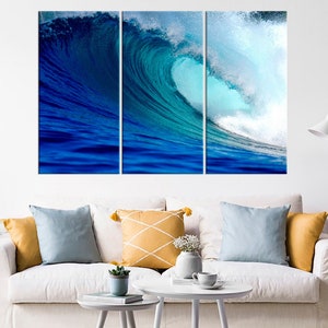 May include: A three-piece canvas print set featuring a large blue wave crashing in the ocean. The wave is a vibrant blue and green color, with white foam at the crest. The print is perfect for adding a touch of nature to any room.