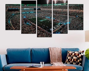 May include: A panoramic view of a football stadium at night, with a green field and a large crowd of people. The stadium is lit up with bright lights, and there are fireworks in the sky. The image is split into five panels, creating a multi-panel wall art piece.